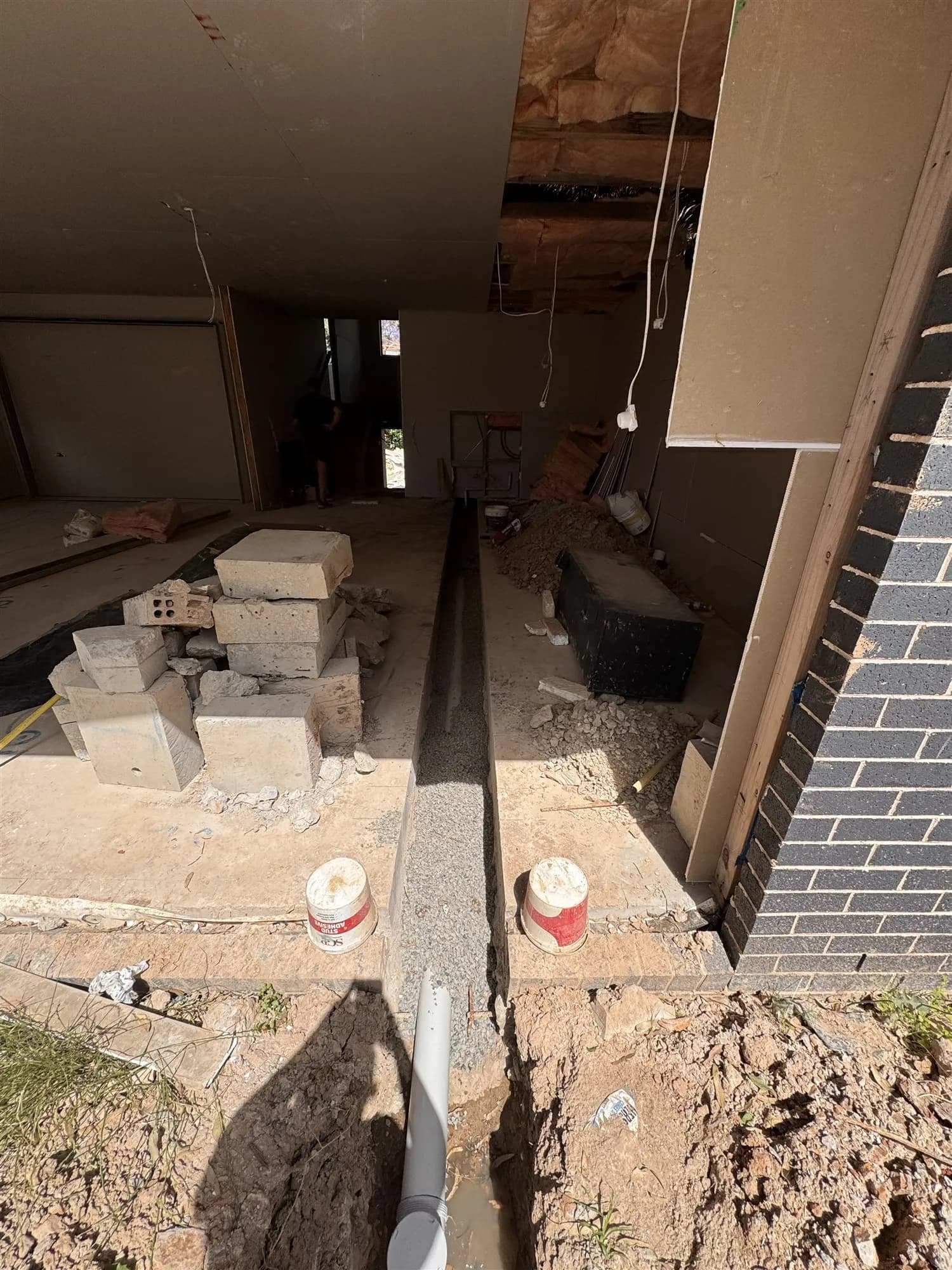 Saw-cut trench in a concrete slab running out to the yard for new drainage