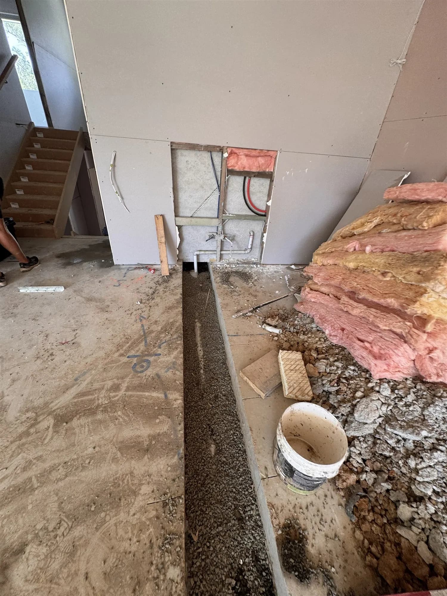 Trench cut through the concrete floor slab for a new drainage line