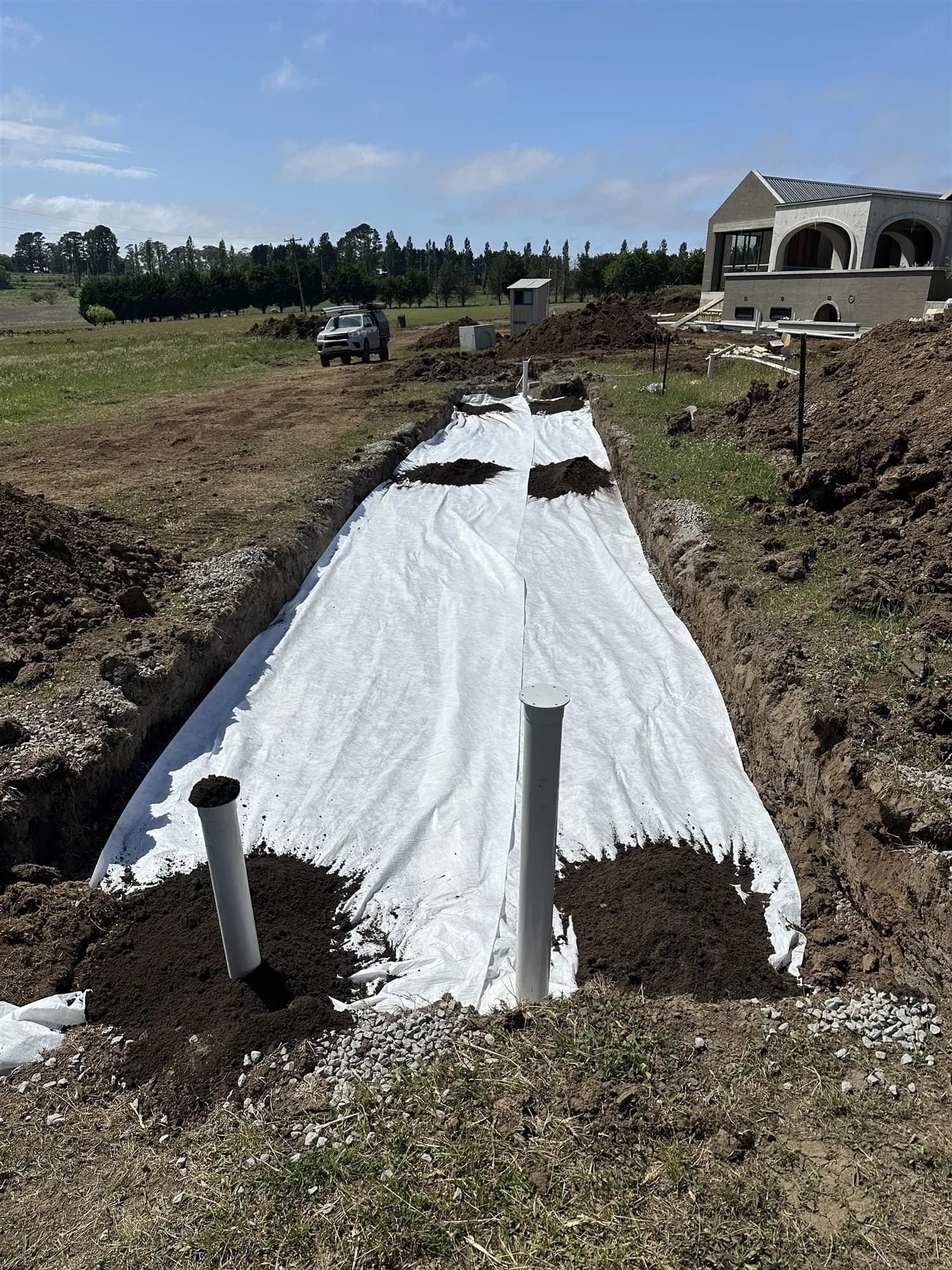 Absorption trench covered in geofabric with inspection risers