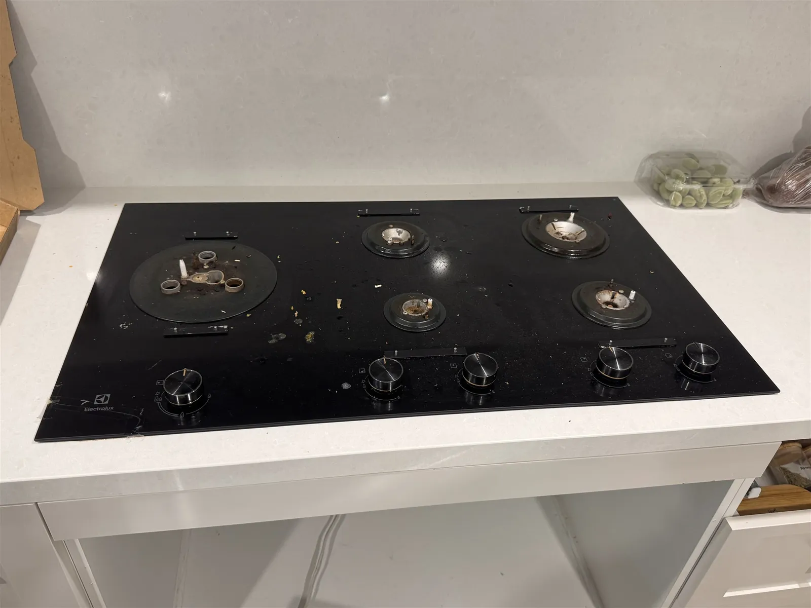 Old black glass gas cooktop with cracked glass, before replacement