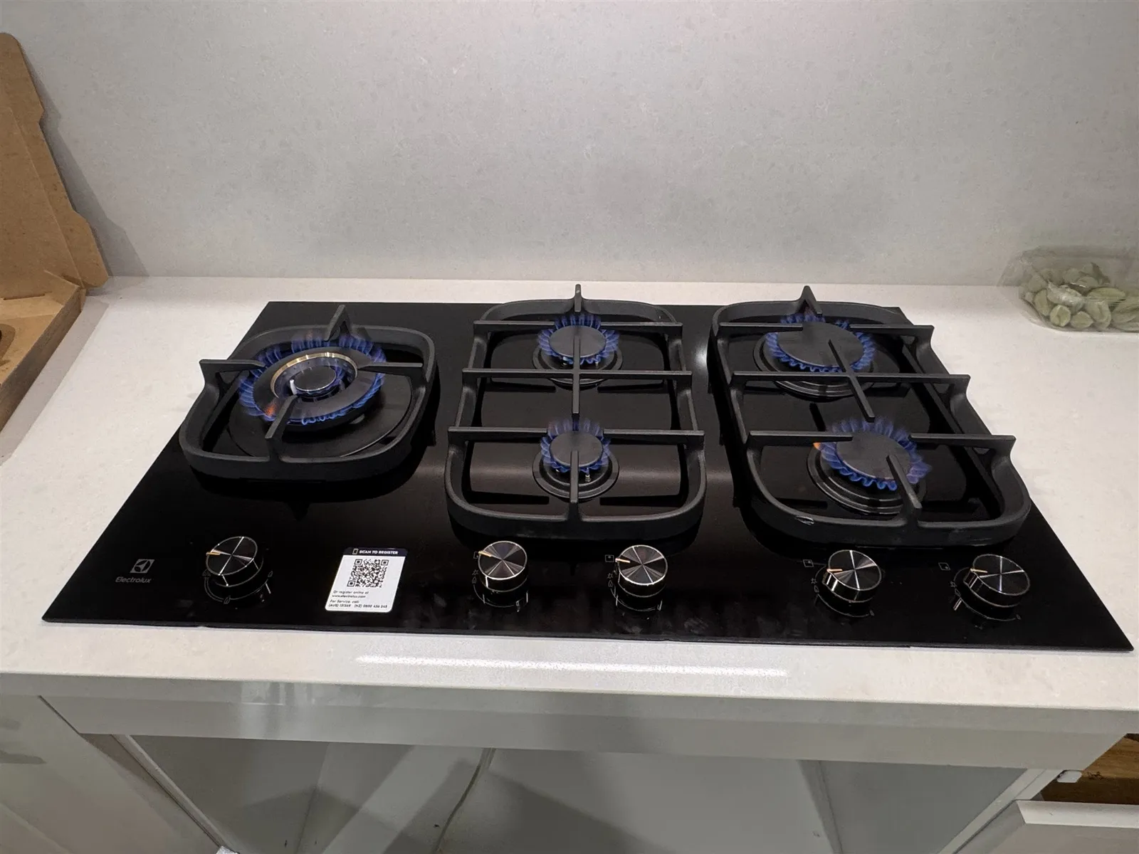 New five-burner gas cooktop installed with all burners lit