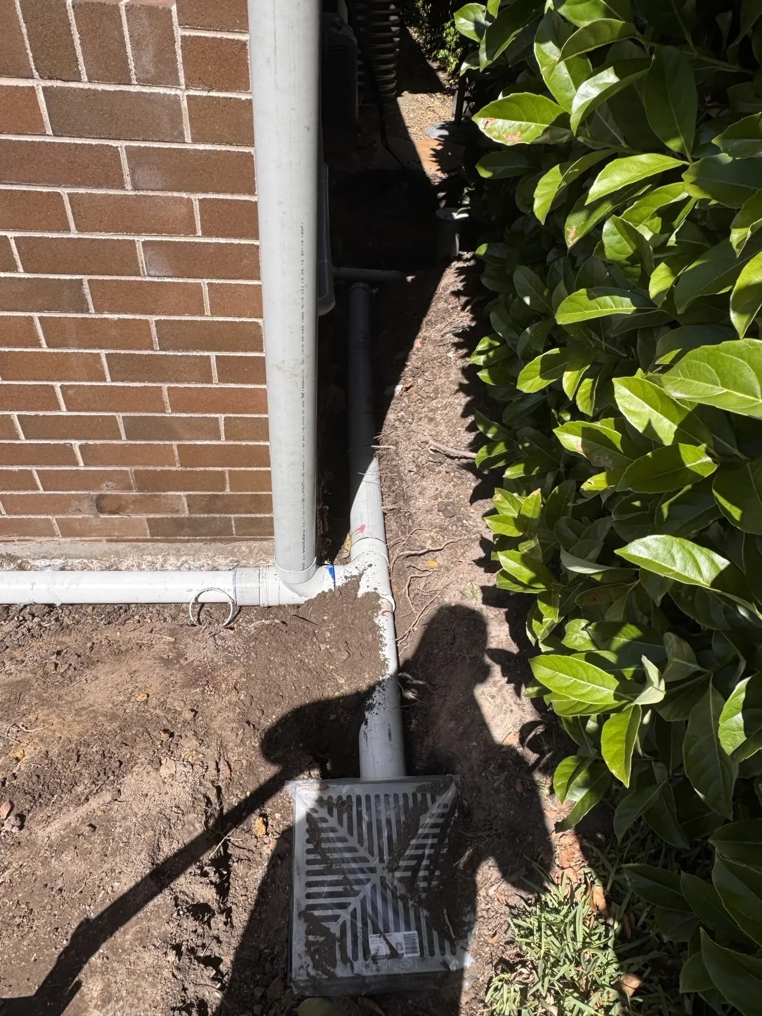 Strip drain connected into a grated stormwater pit beside the house