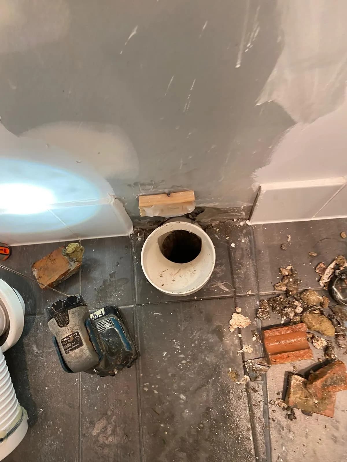 Toilet removed with brick and debris pulled out of the sewer connection