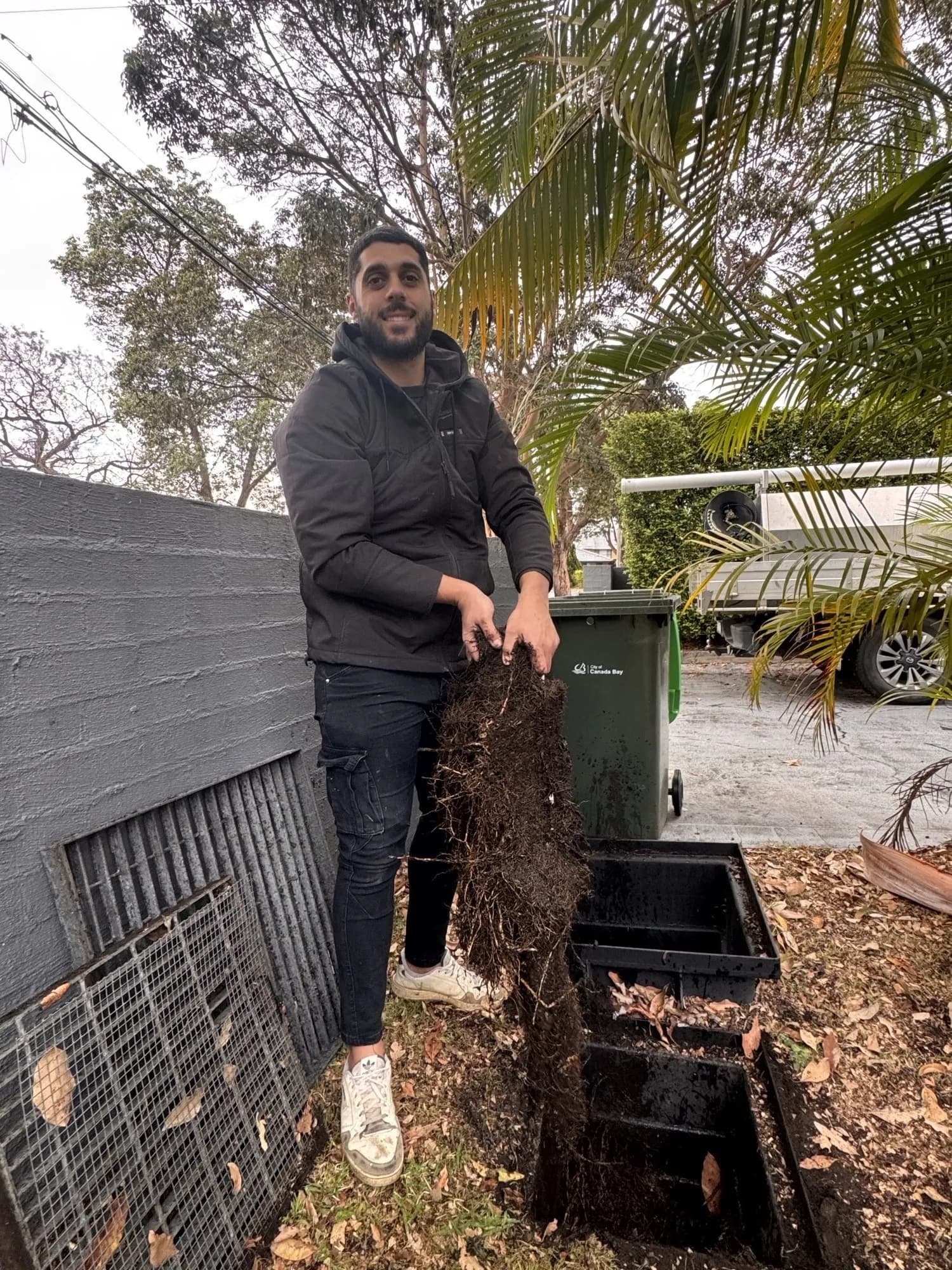 Mr Clog plumber Matthew holding a mat of tree roots pulled from a stormwater pit