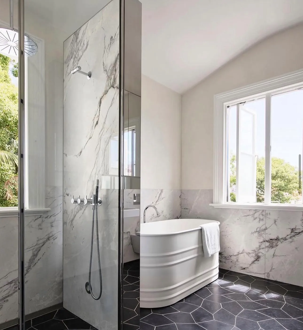 Marble bathroom with walk-in shower, freestanding bath and hexagon floor tiles