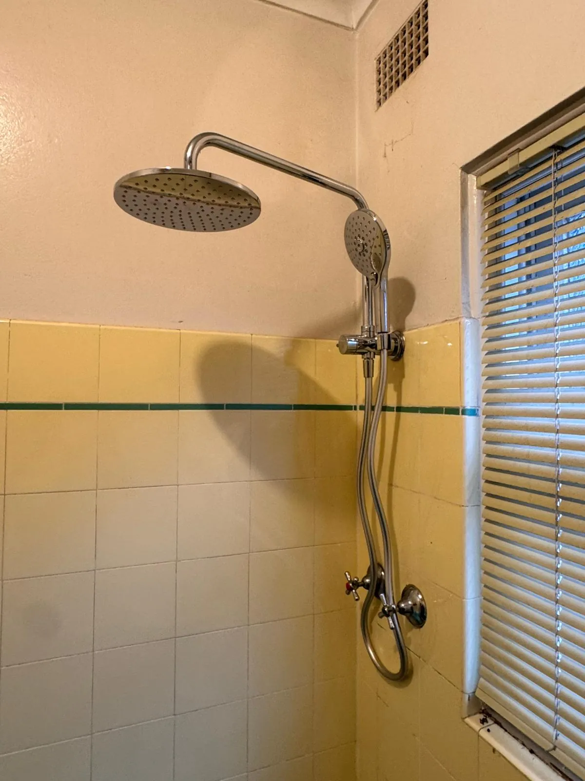 The same shower recess fitted with a rain head and hand shower on a rail