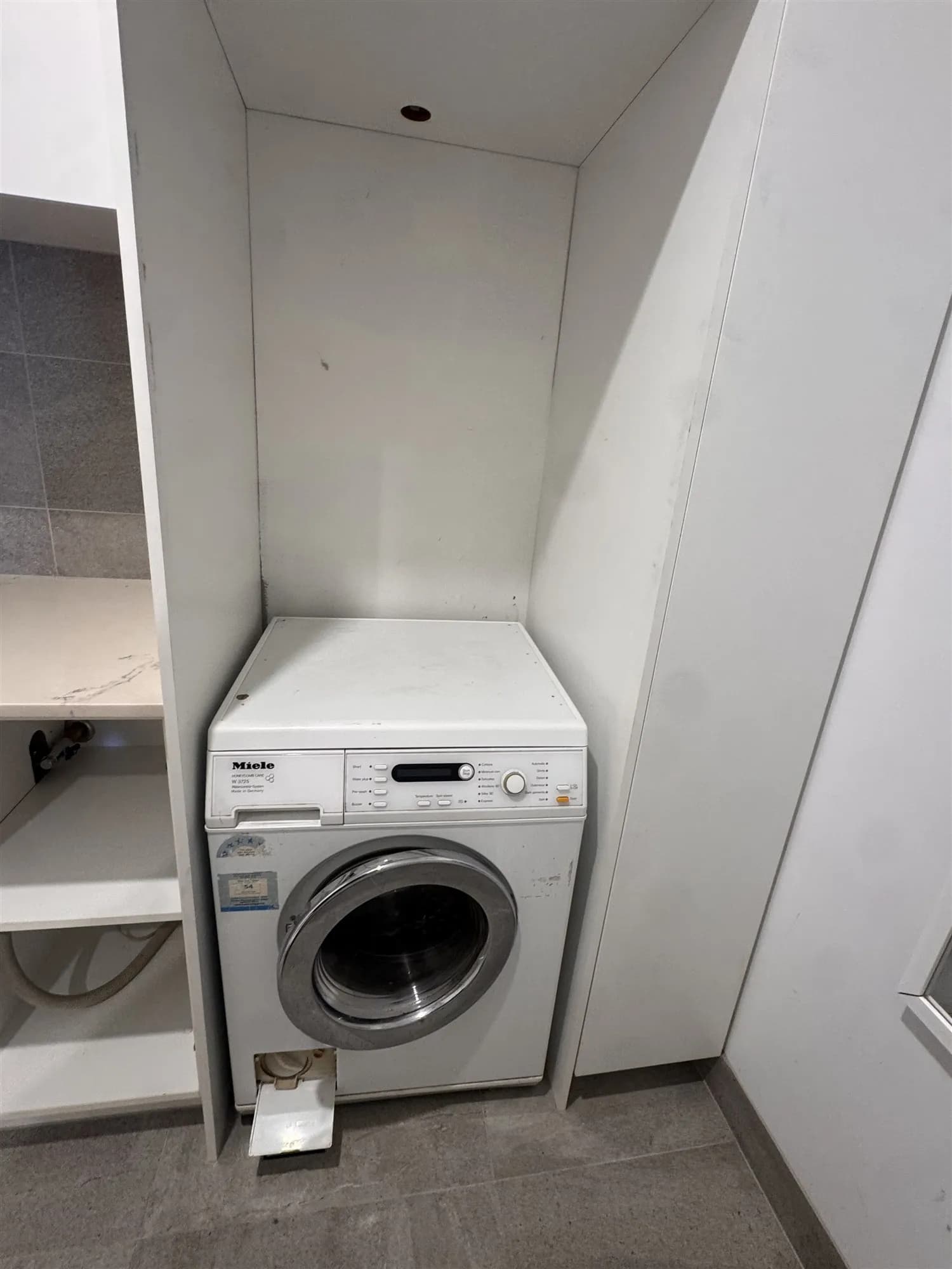 Before: the old front-loading washing machine in its laundry cabinet