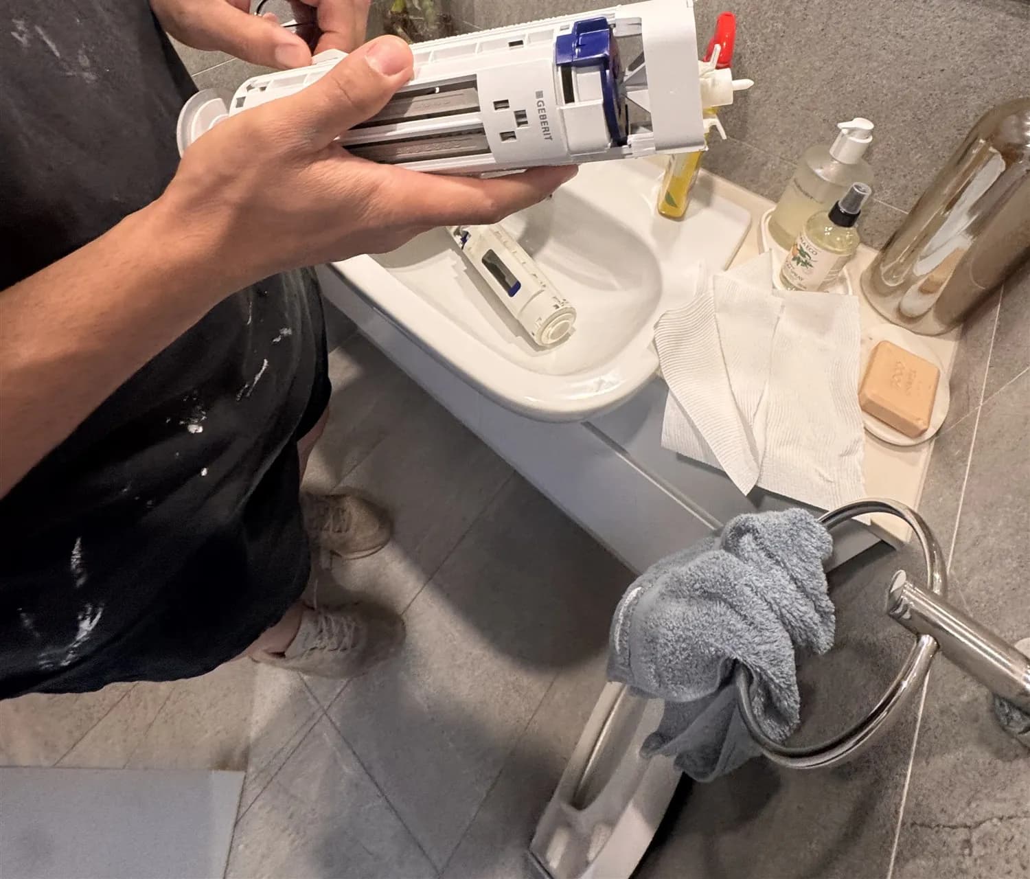 Plumber holding the new toilet outlet (flush) valve ready to fit