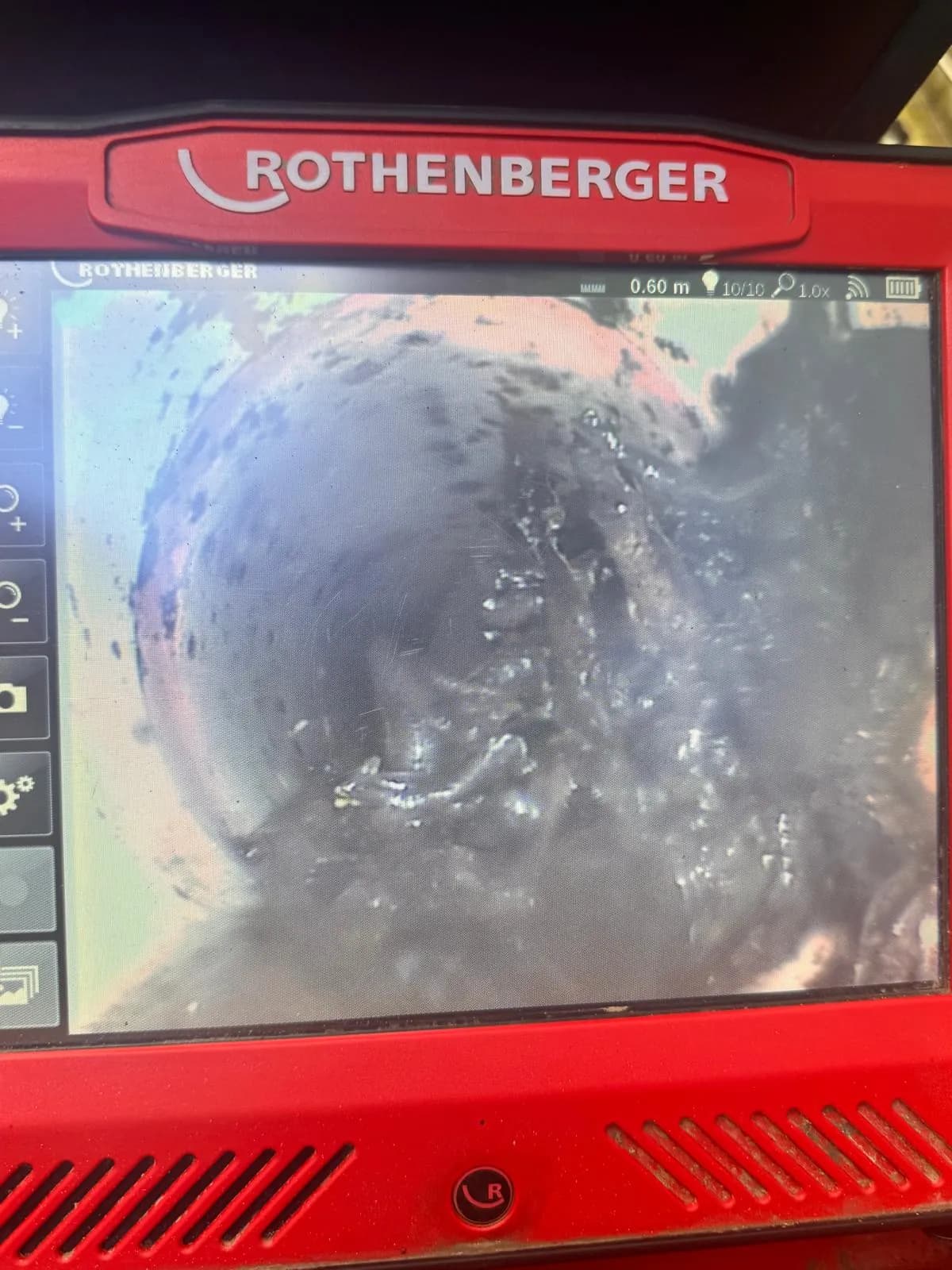 Drain camera screen showing a pipe coated in scale and debris at 0.60 metres from the inspection point