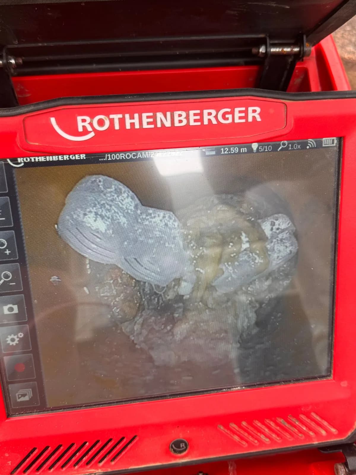 Drain camera screen showing tree roots growing through a pipe joint 12.59 metres down the line