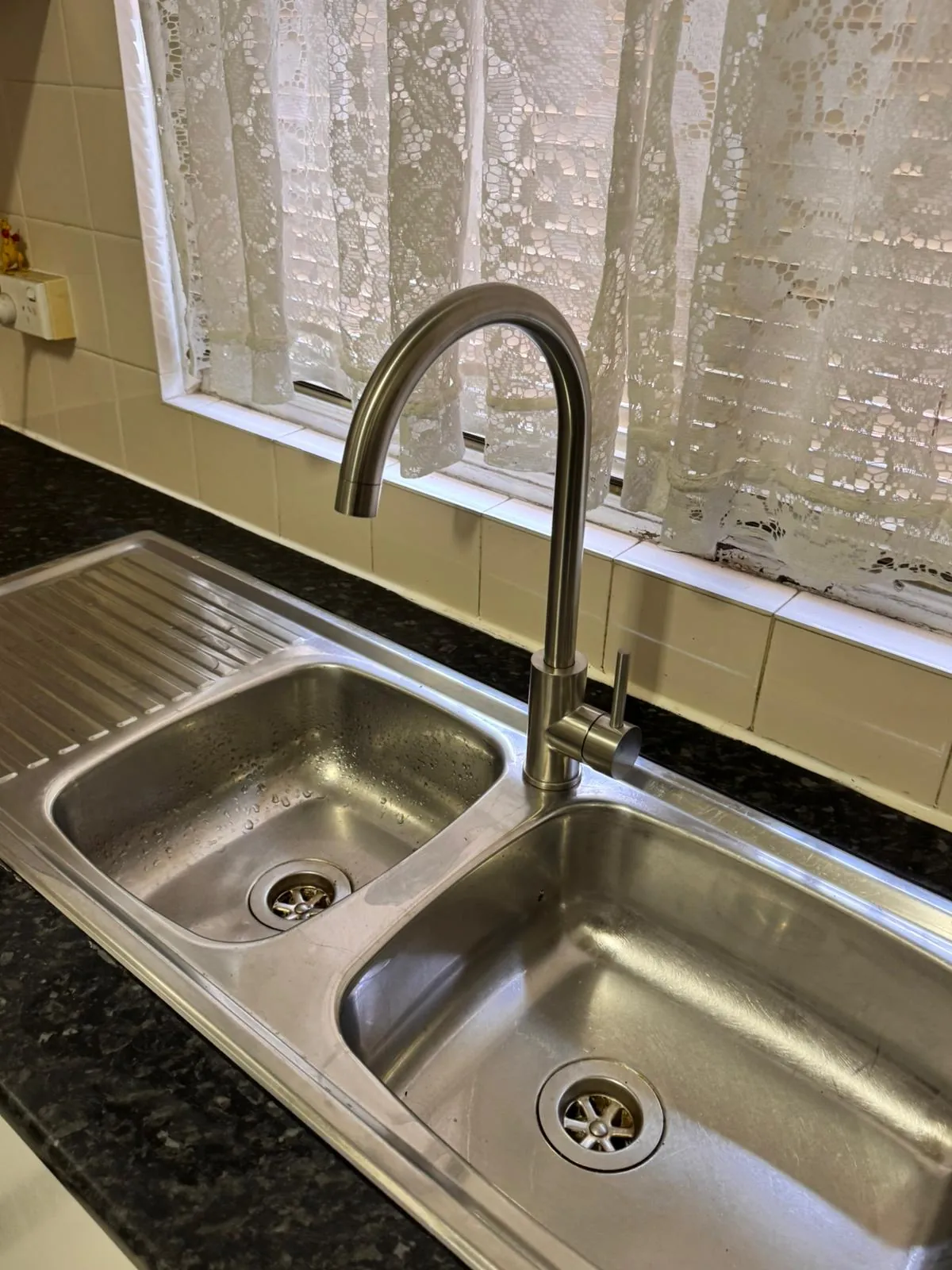 New brushed-finish gooseneck mixer tap fitted to the same double-bowl kitchen sink