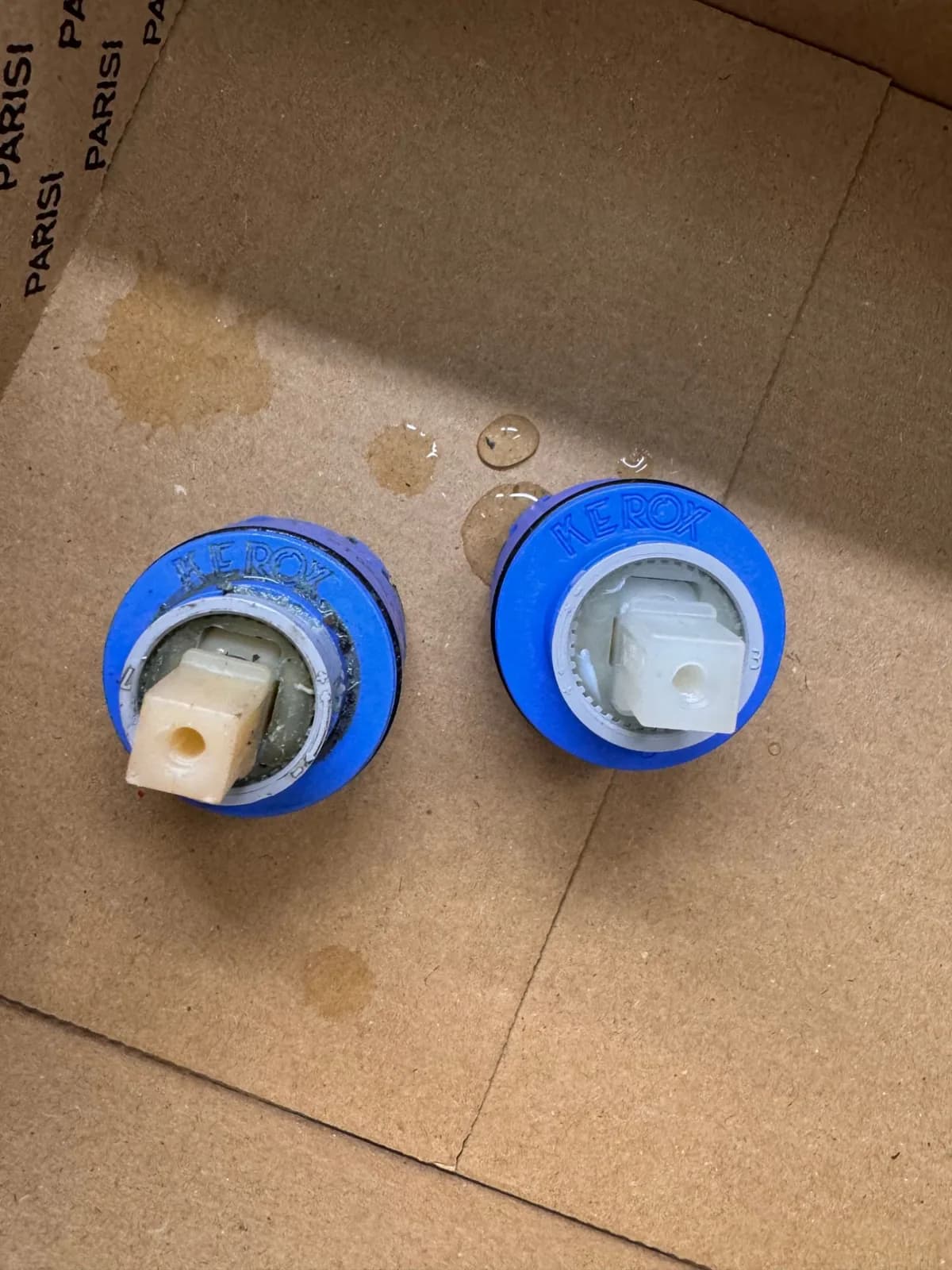 A worn, scaled-up tap cartridge next to a clean replacement cartridge